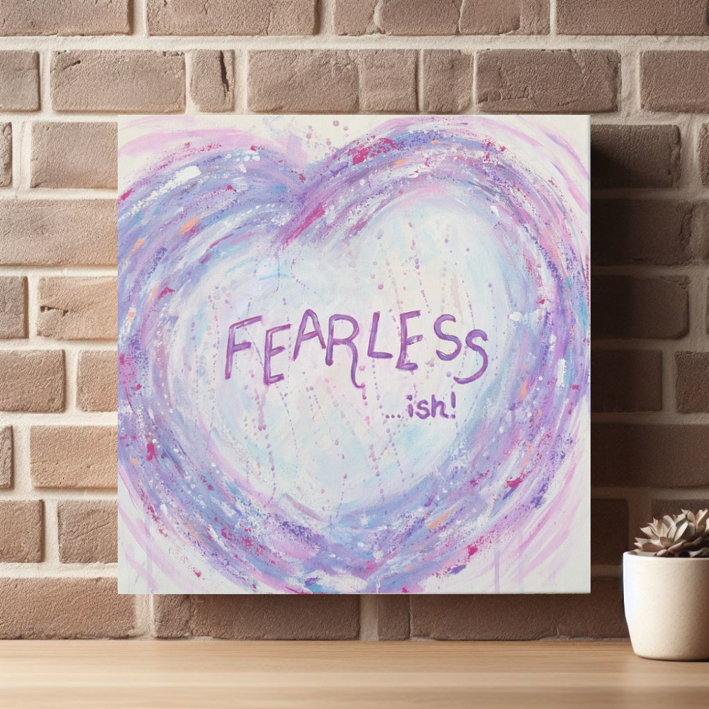 Fearless - ish canvas print by Julie Hogarth-Jones styled against a brick wall with a shelf and plant. 