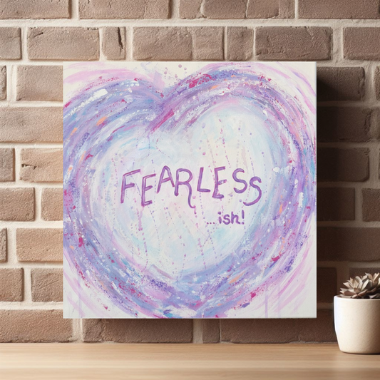 Fearless - ish canvas print by Julie Hogarth-Jones styled against a brick wall with a shelf and plant. 