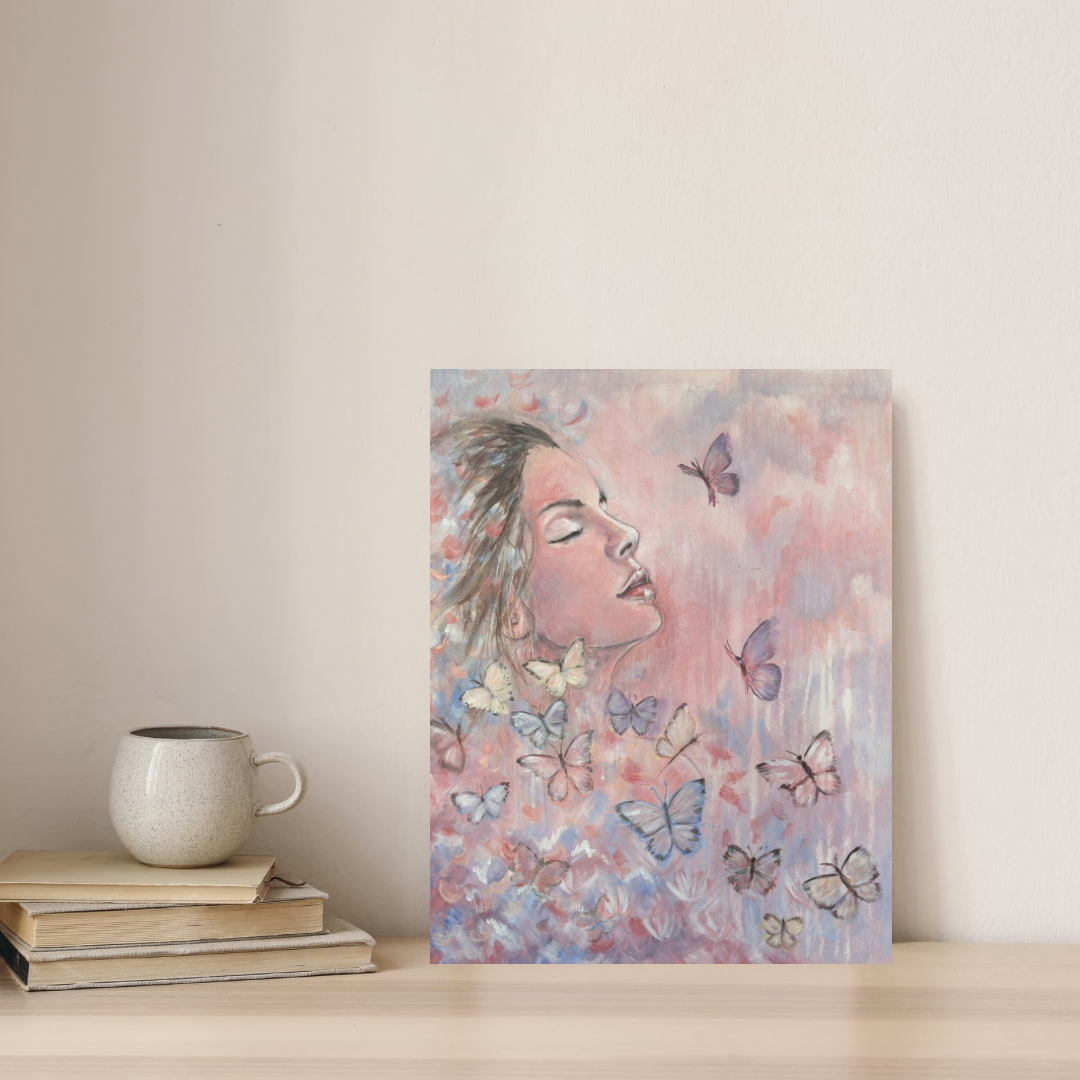 Metamorphosis canvas print of a woman with butterflies  by Julie Hgoarth-Jones displayed on a shelf in a styled home setting. 