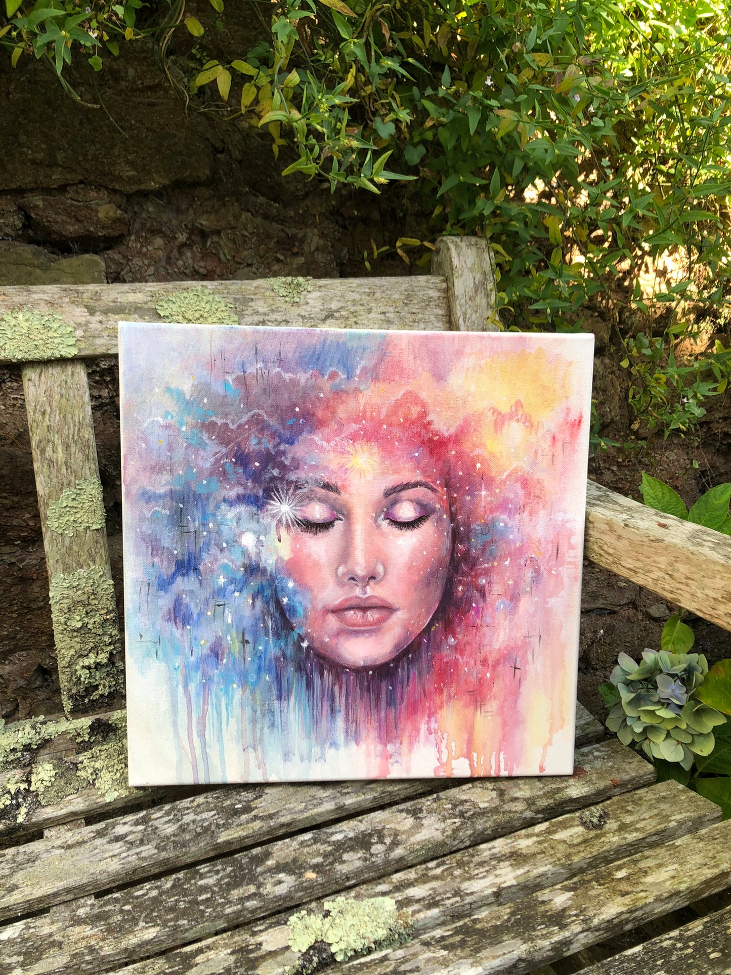 We Are All Made of Stars original painting by Julie Hogarth-Jones photographed on a bench outdoors. 